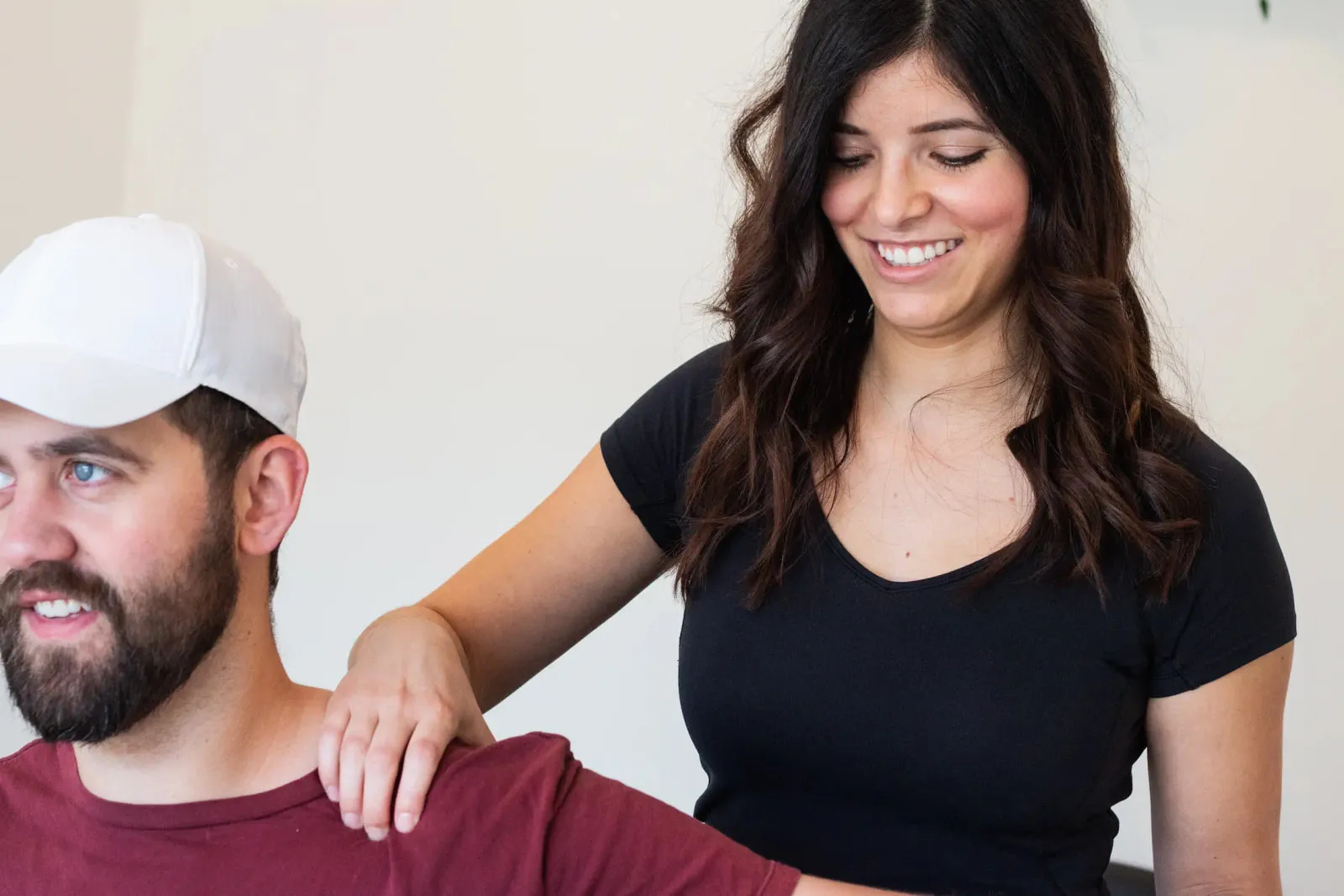 Dr. Natalie Lopez talking with a patient during an appointment, one hand resting on their shoulder.