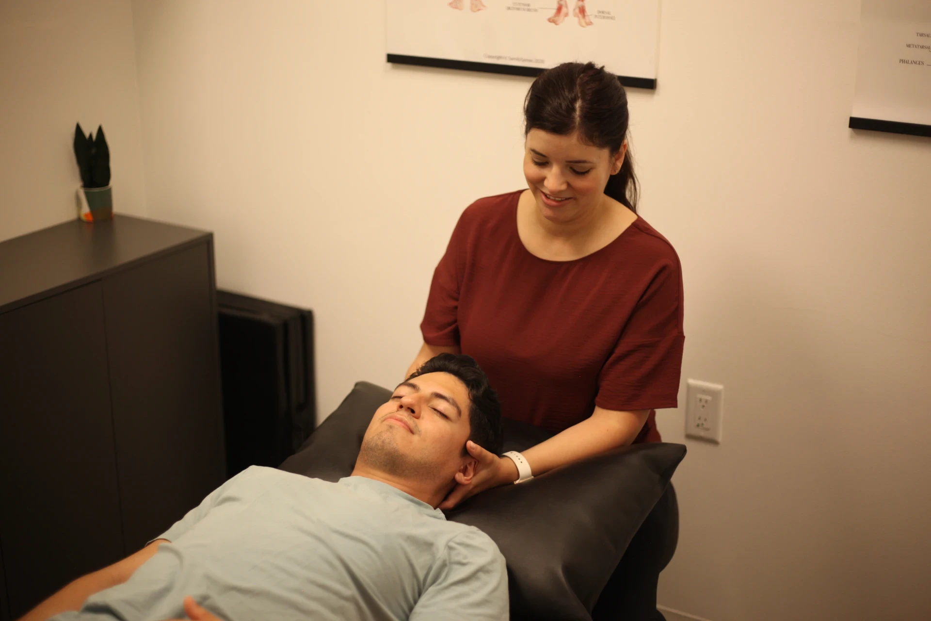 Dr. Natalie supporting a patient's neck during a treatment appointment.