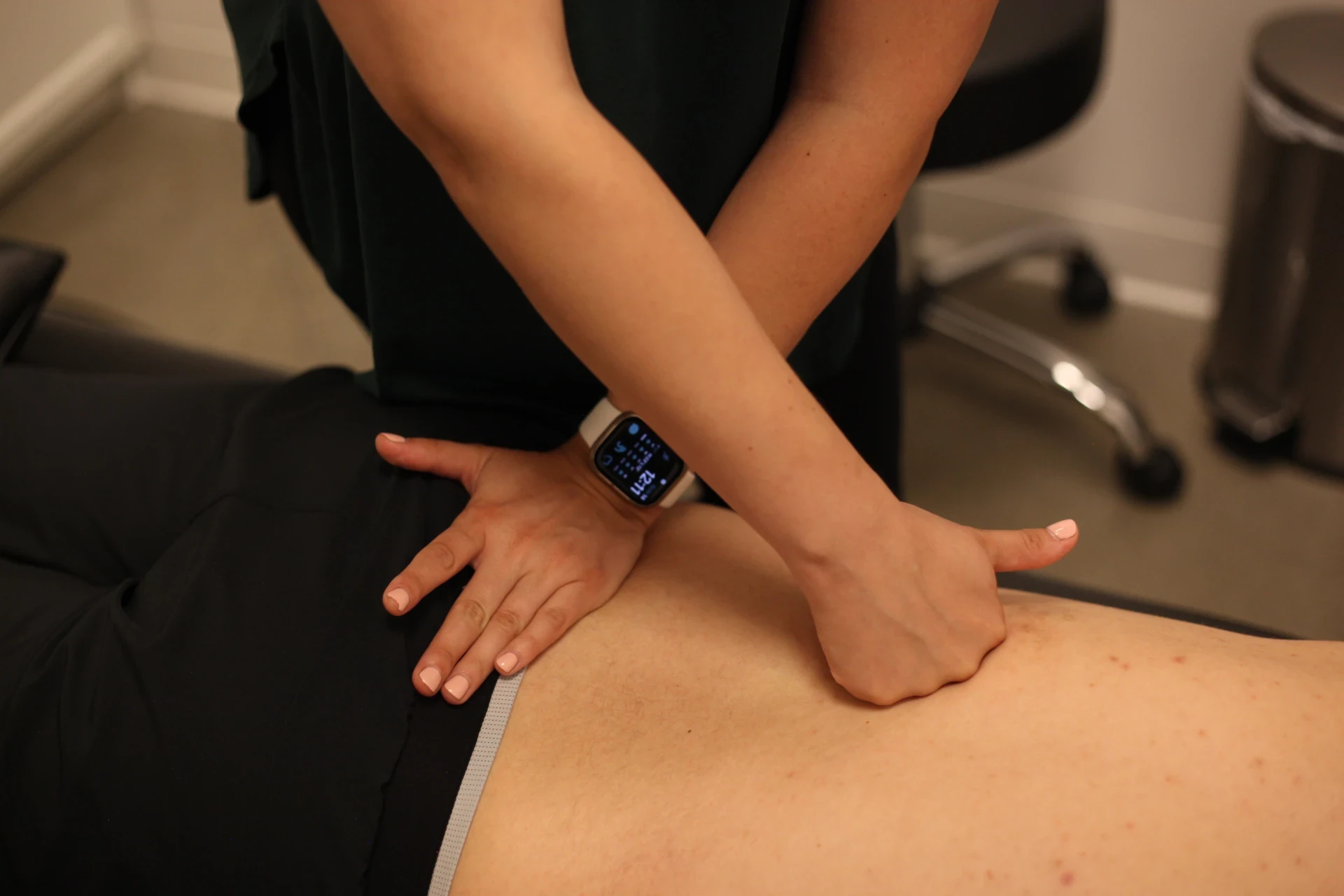Dr. Natalie providing hands-on soft-tissue treatment to a patient's upper back.