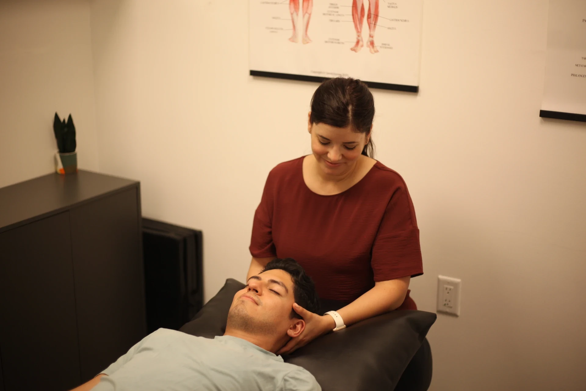 Dr. Natalie providing hands-on neck treatment to a patient lying on a treatment table.
